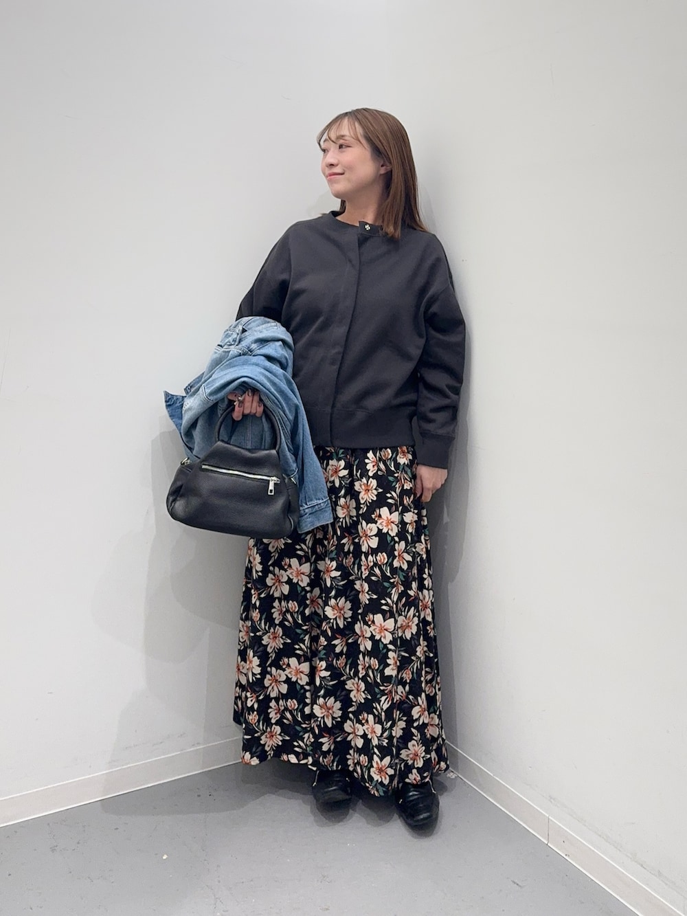 ブルー系のデニムジャケット、グレー系のカーディガン/ボレロ、ブラック系のスカートを着用したレディースの冬コーディネートの7枚目の写真