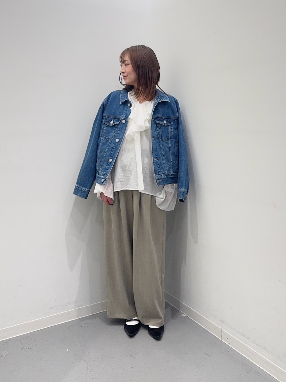 ブルー系のデニムジャケット、ホワイト系のシャツ/ブラウス、ベージュ系のその他パンツを着用したレディースの春コーディネートの4枚目の写真