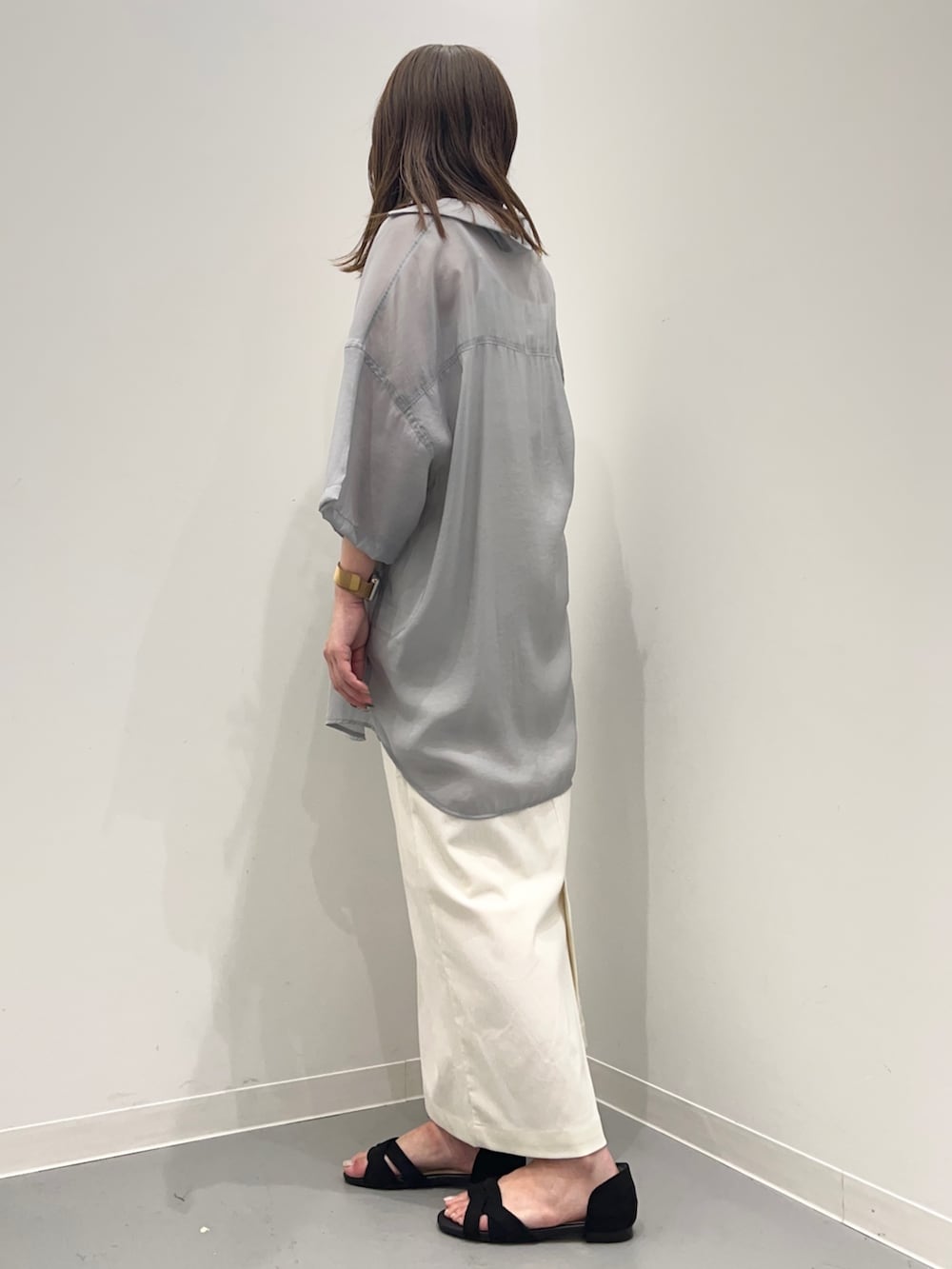 グレー系のシャツ/ブラウス、ホワイト系のスカート、ブラック系のサンダルを着用したレディースの夏コーディネートの3枚目の写真