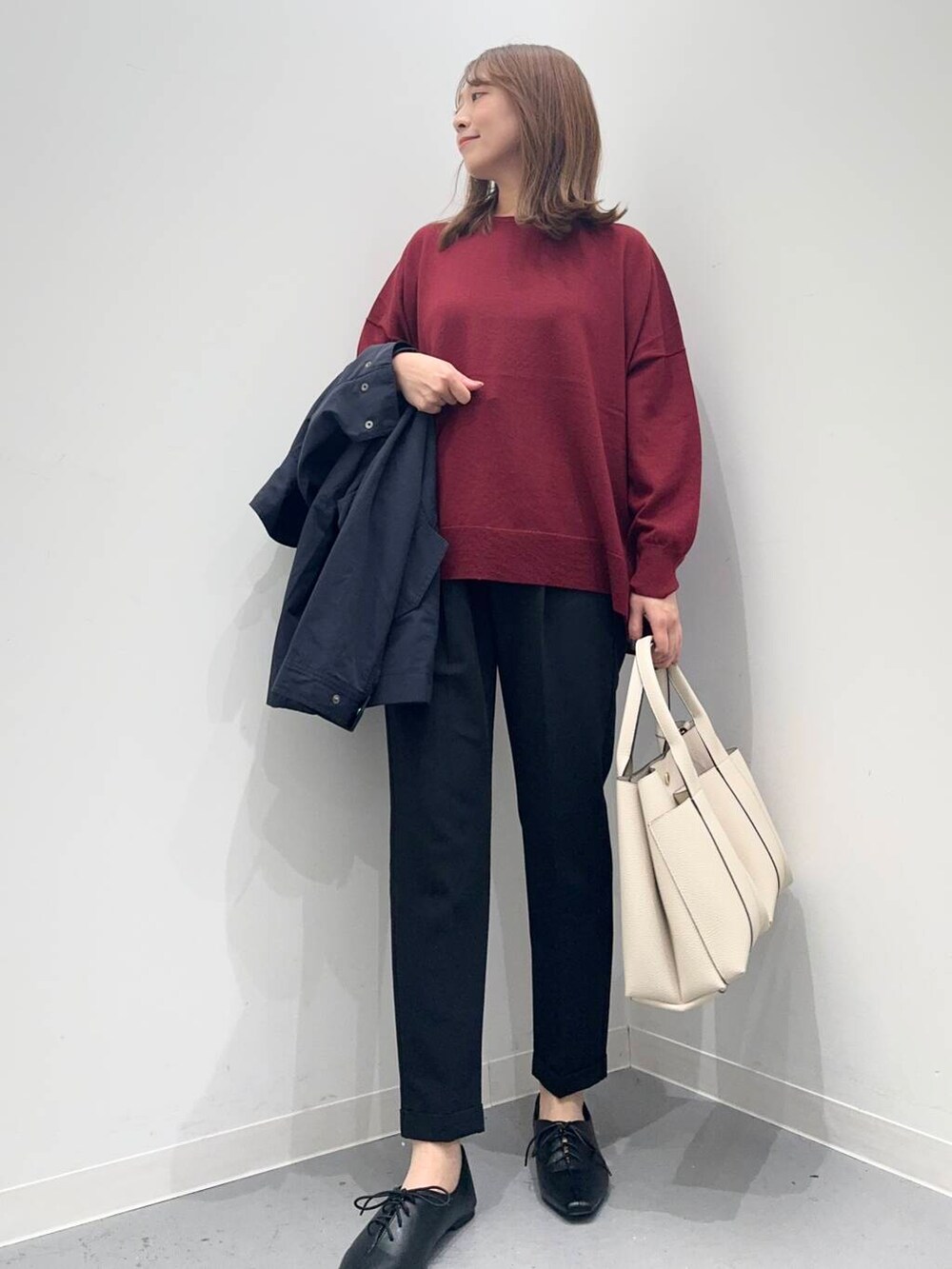 ブラック系のトートバッグ、レッド系のニット/セーター、ブラック系のその他パンツを着用したレディースの秋コーディネートの6枚目の写真
