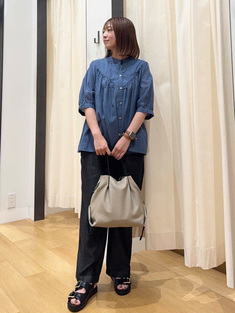 ベージュ系のショルダーバッグ、ブラック系のサンダル、ブラック系のデニムパンツを着用したレディースの夏コーディネートの5枚目の写真