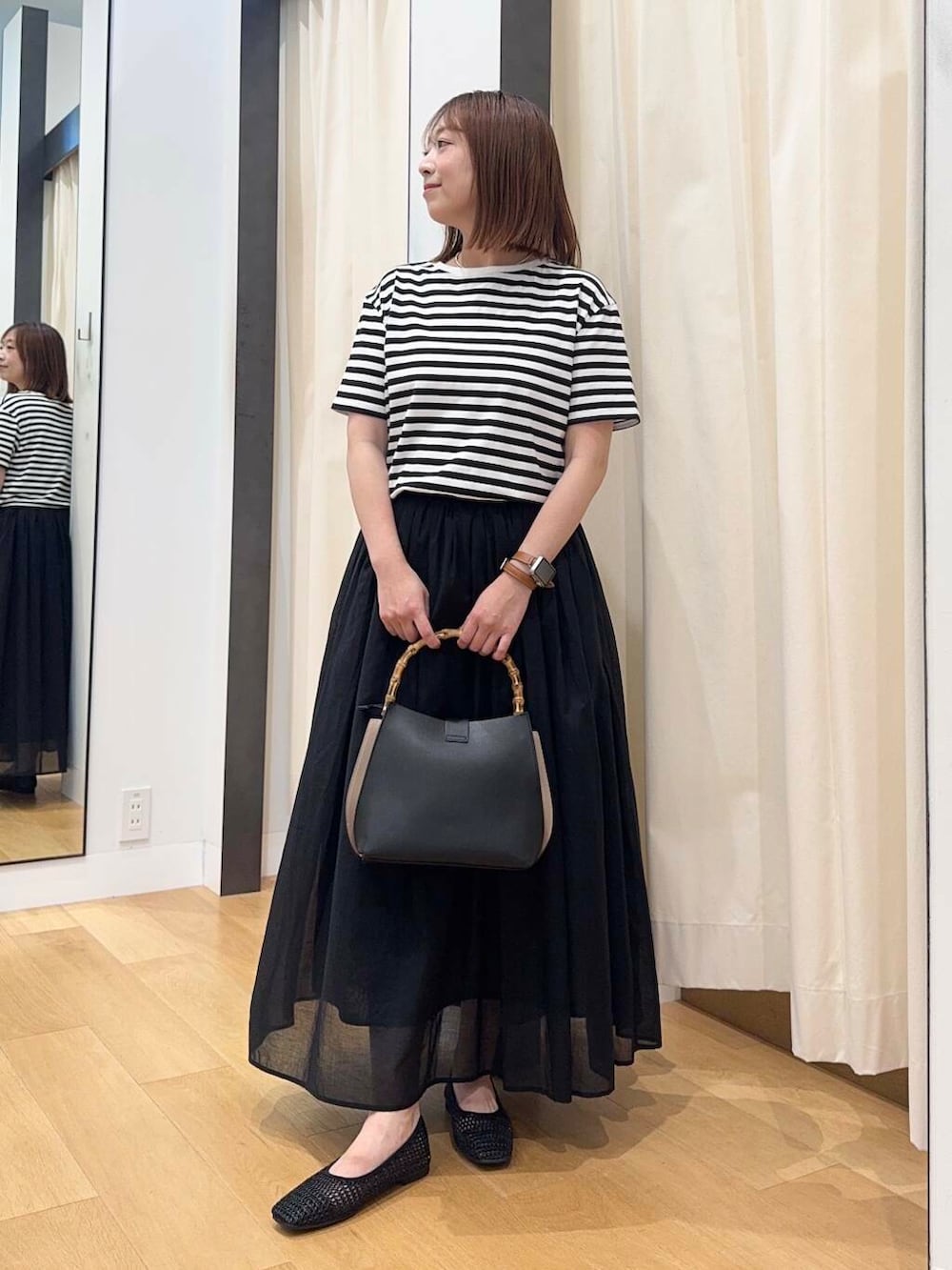 ブラック系のバレエシューズ、ブラック系のワンピース、ブラック系のハンドバッグを着用したレディースの夏コーディネートの2枚目の写真