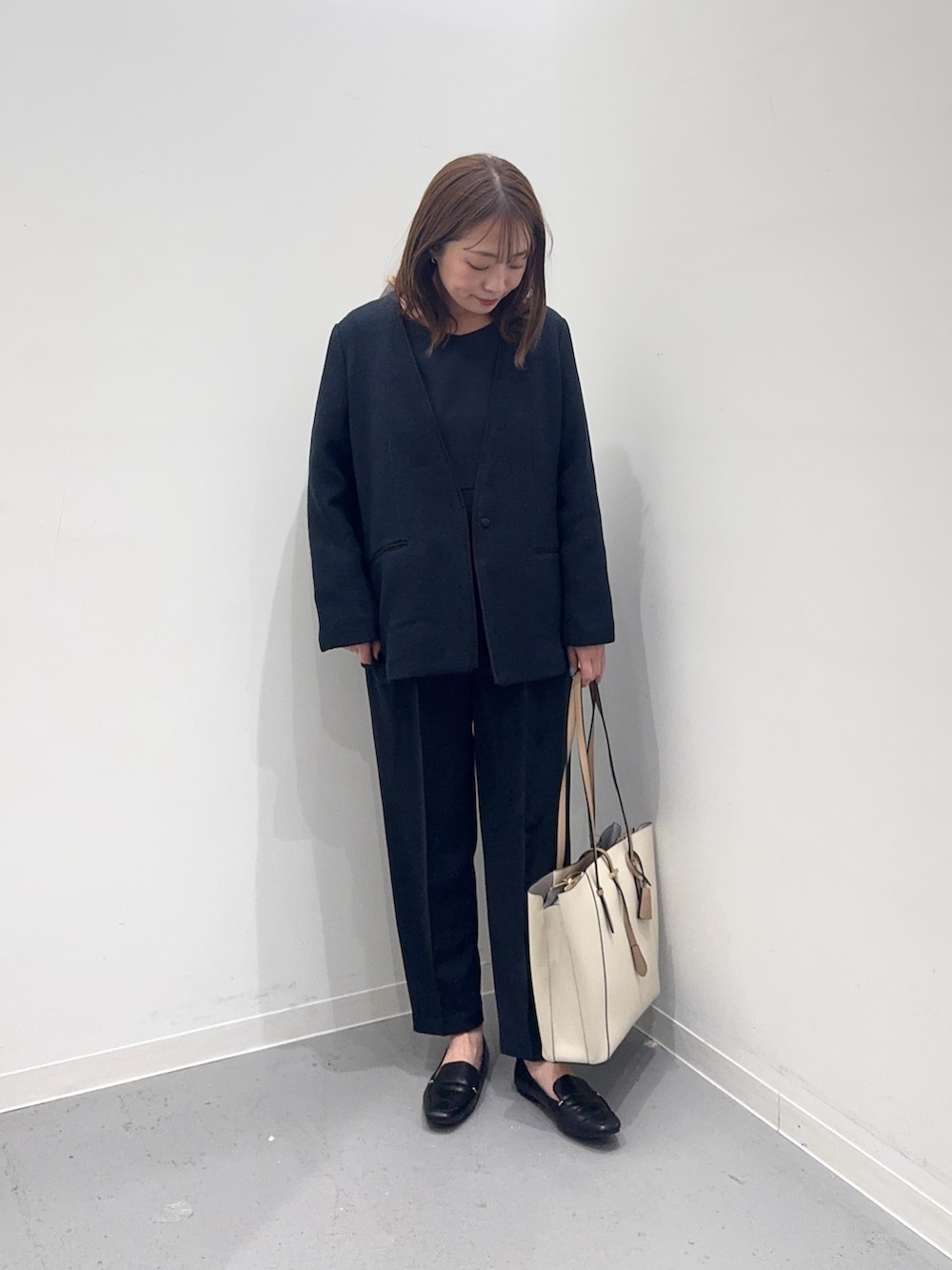 ブルー系のセットアップ、ブルー系のスーツジャケット、ホワイト系のトートバッグを着用したレディースの冬コーディネートの3枚目の写真