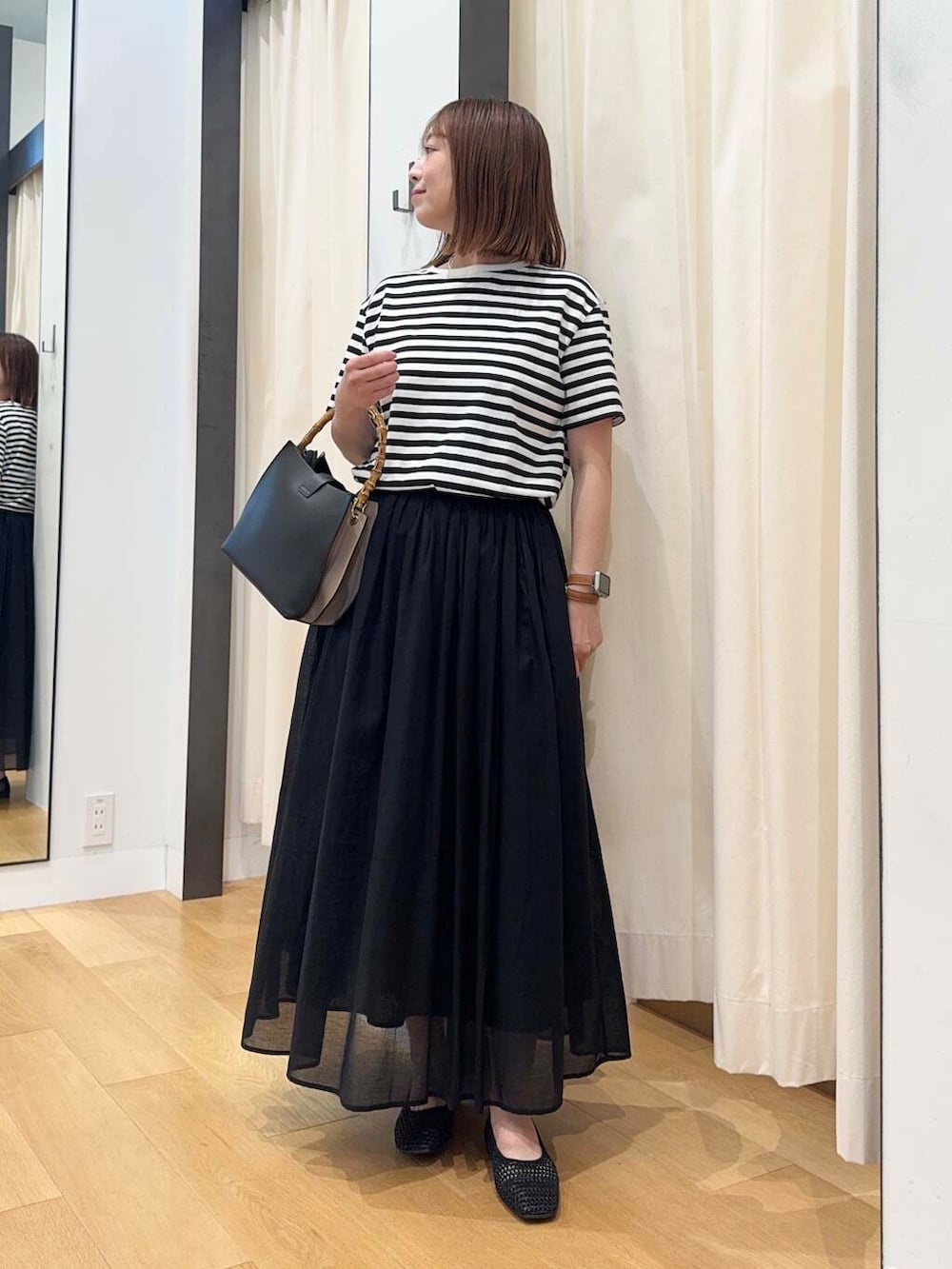 ブラック系のバレエシューズ、ブラック系のワンピース、ブラック系のハンドバッグを着用したレディースの夏コーディネートの3枚目の写真