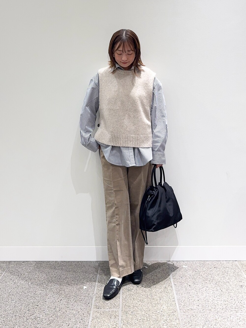 ブルー系のシャツ/ブラウス、ベージュ系のその他パンツ、ブラック系のローファーを着用したレディースの秋コーディネートの5枚目の写真