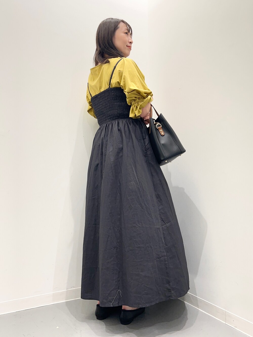 グレー系のワンピース、イエロー系のTシャツ/カットソーを着用したレディースの夏コーディネートの4枚目の写真