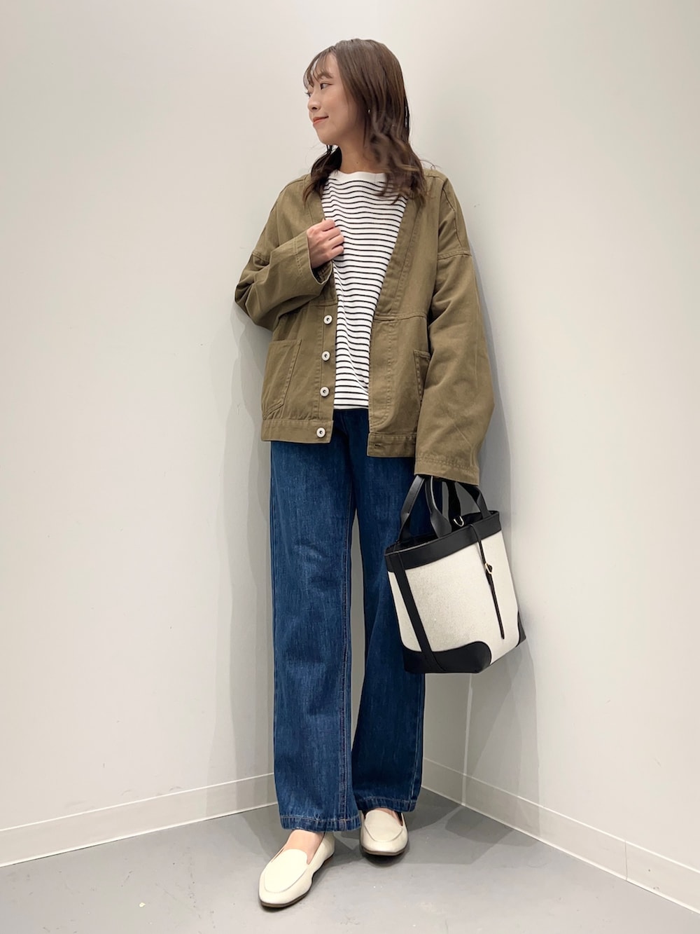 ブルー系のデニムパンツ、グリーン系のその他アウター、ホワイト系のTシャツ/カットソーを着用したレディースの秋コーディネートの2枚目の写真