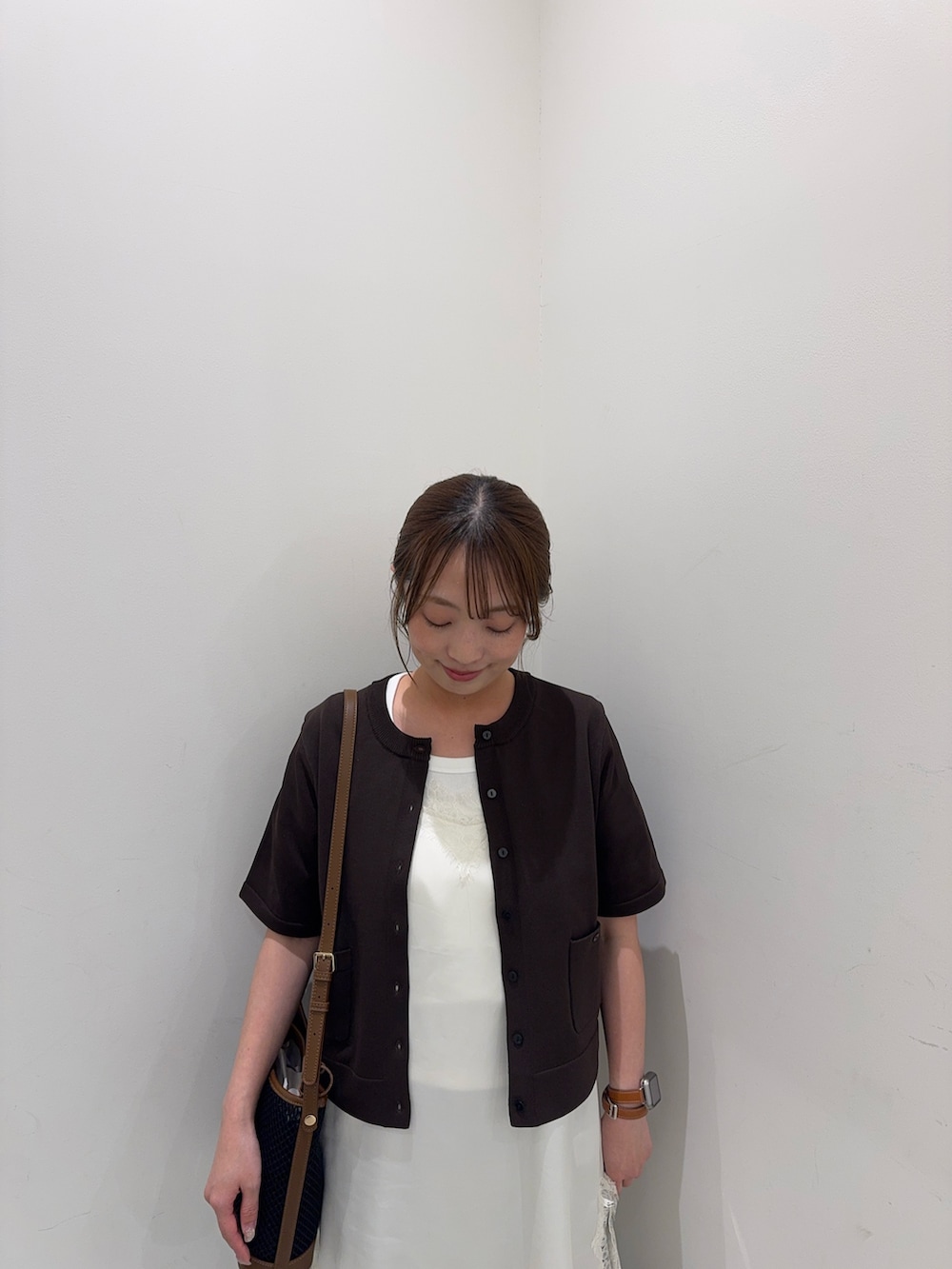ブラウン系のカーディガン/ボレロ、ホワイト系のキャミソール、ブルー系のデニムパンツを着用したレディースの春コーディネートの7枚目の写真