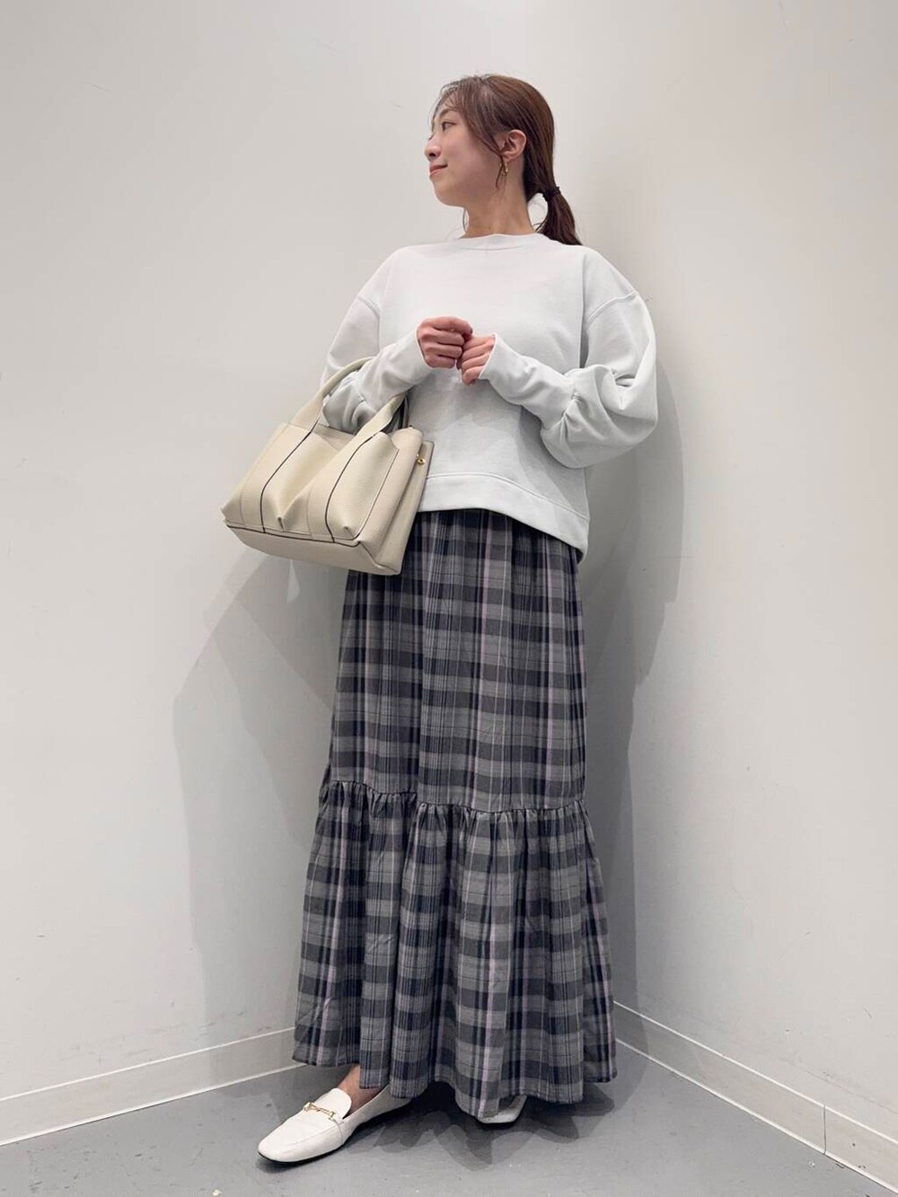 ホワイト系のトートバッグ、ホワイト系のローファー、ホワイト系のスウェットを着用したレディースの春コーディネートの4枚目の写真