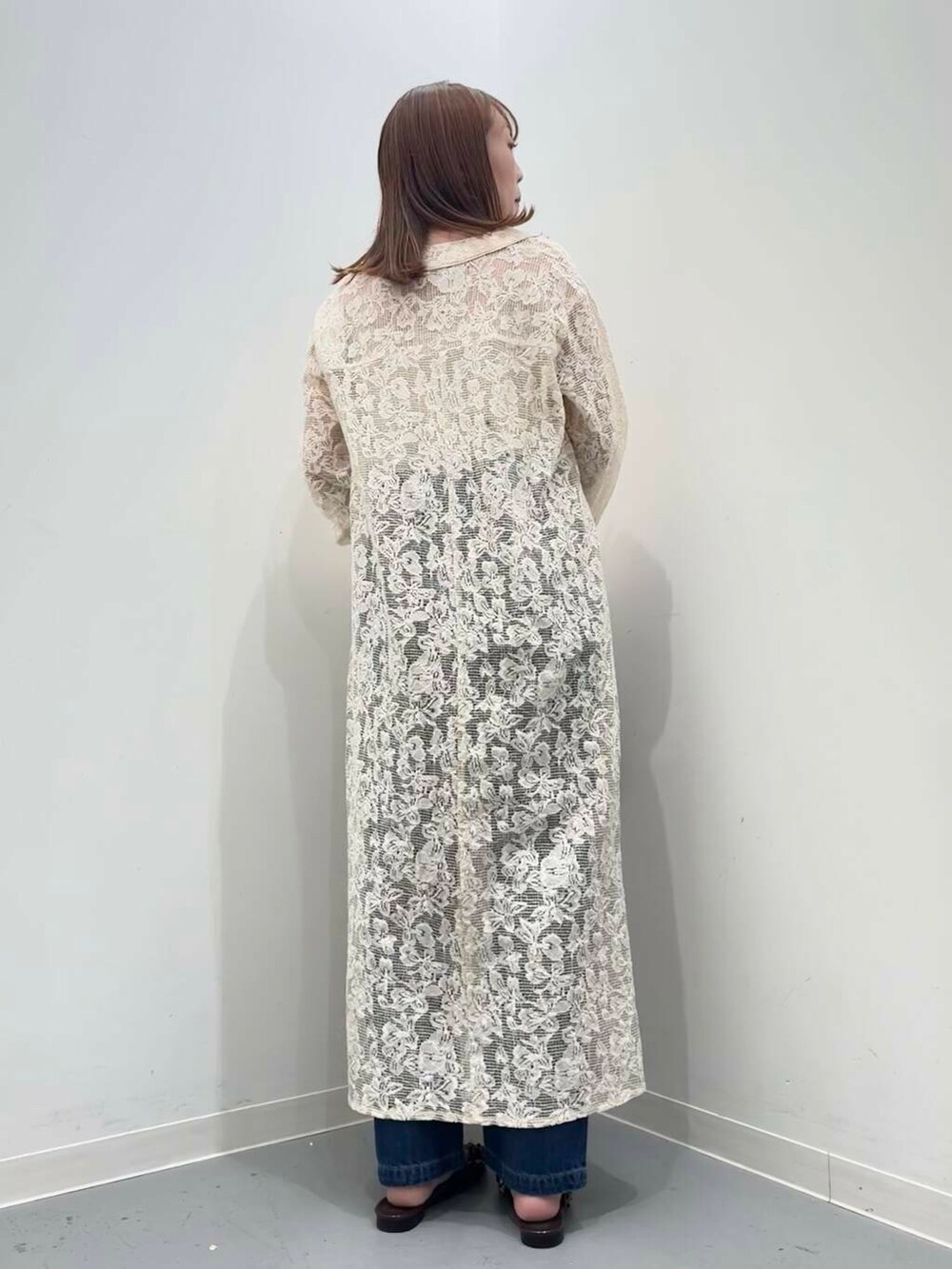 ブラウン系のハンドバッグ、ブルー系のデニムパンツ、ブラウン系のその他シューズを着用したレディースの秋コーディネートの4枚目の写真