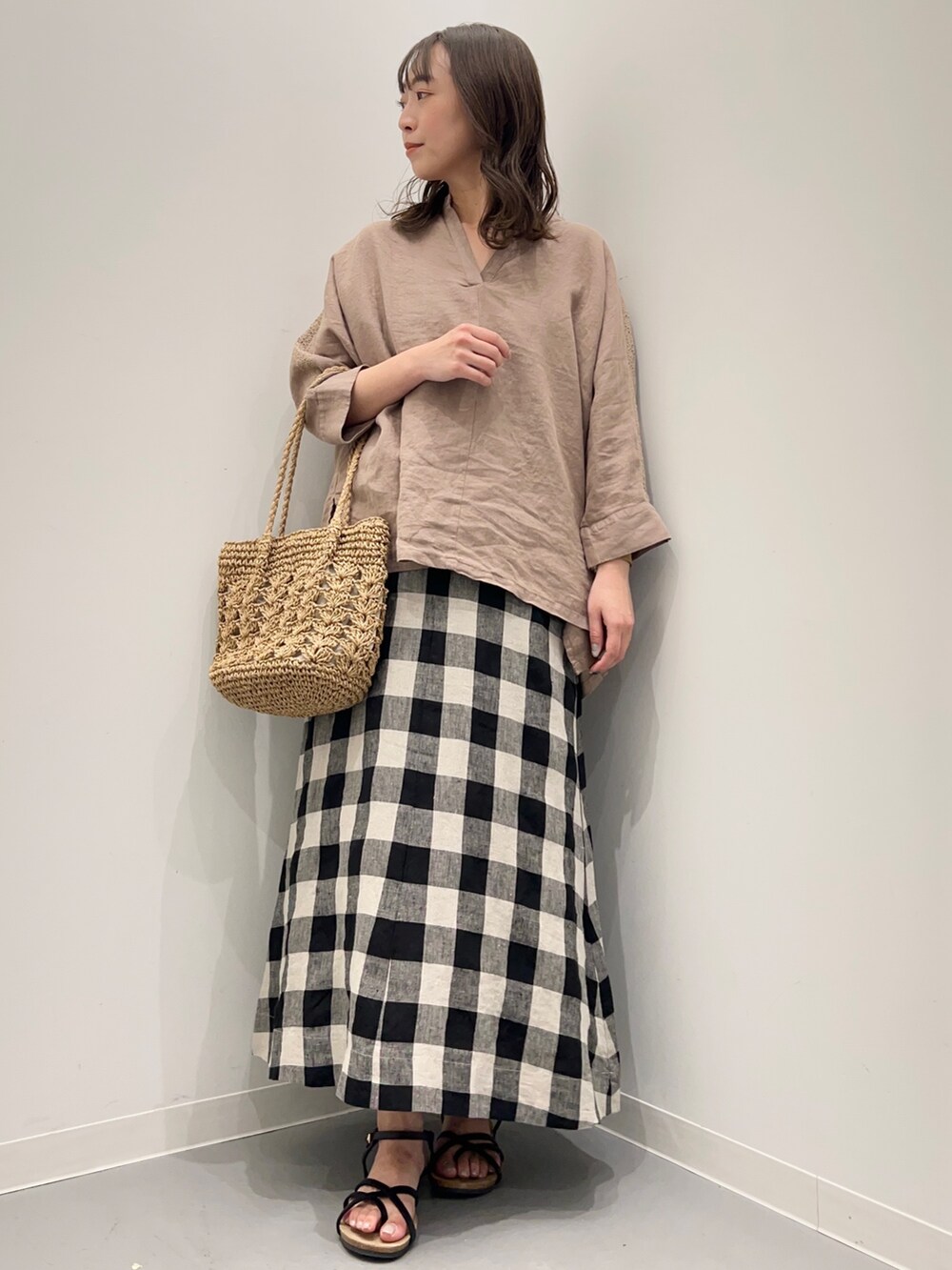 ブラウン系のシャツ/ブラウス、ブラック系のスカート、ブラック系のサンダルを着用したレディースの夏コーディネートの2枚目の写真