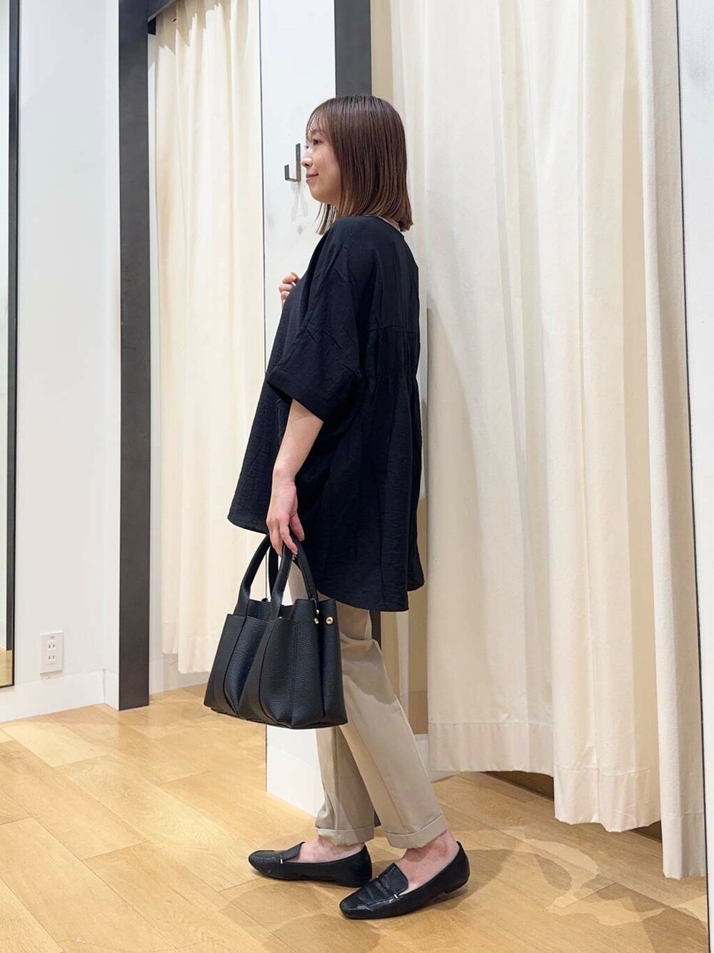 ブラック系のトートバッグ、ベージュ系のその他パンツ、ブラック系のシャツ/ブラウスを着用したレディースの夏コーディネートの4枚目の写真