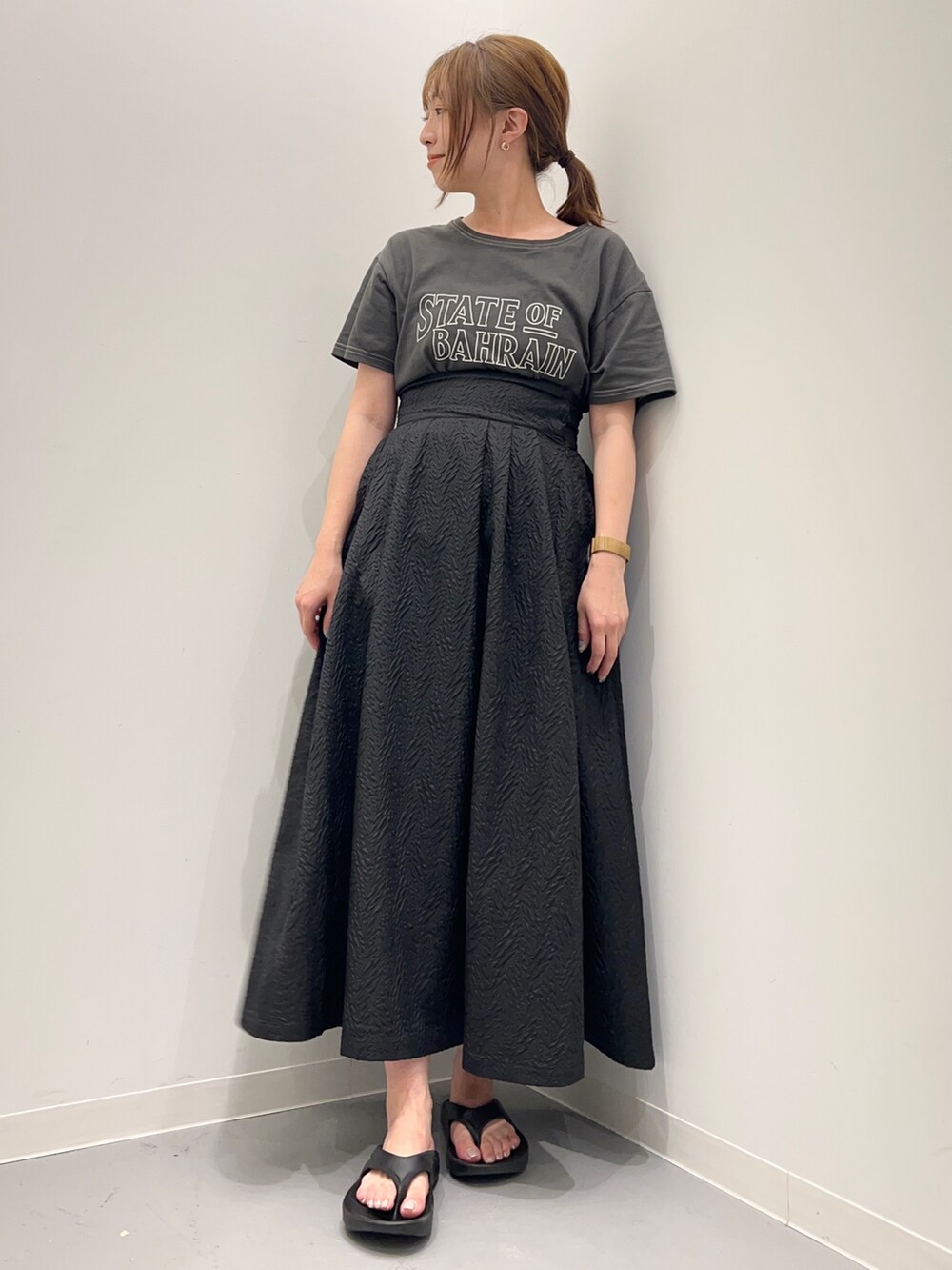 グレー系のTシャツ/カットソー、ブラック系のスカートを着用したレディースの春コーディネートの2枚目の写真