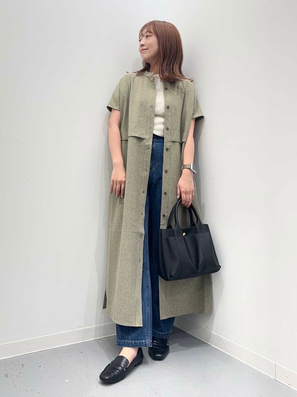 ブラック系のローファー、ブラック系のトートバッグ、ブルー系のデニムパンツを着用したレディースの夏コーディネートの5枚目の写真