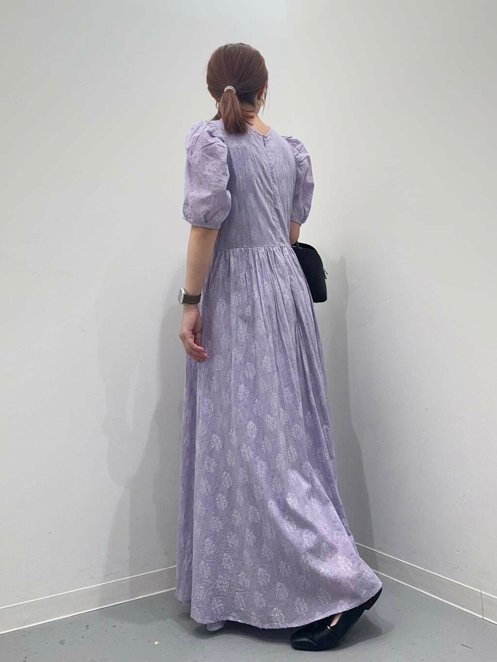 ブラック系のローファー、ブラック系のボストンバッグ、パープル系のワンピースを着用したレディースの夏コーディネートの3枚目の写真