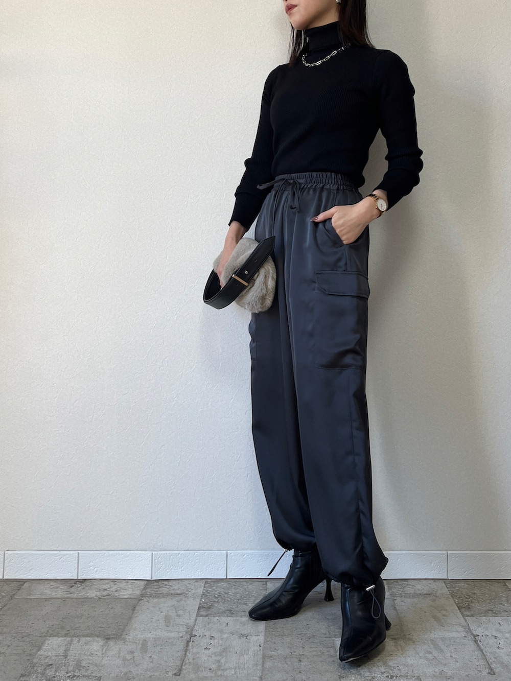 ブラック系のニット/セーター、グレー系のカーゴパンツを着用したレディースの秋コーディネートの2枚目の写真