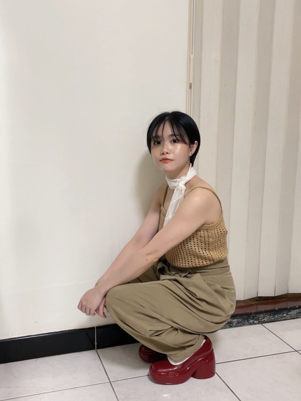 ブラウン系のジャンパースカート、レッド系のパンプスを着用したレディースの夏コーディネートの2枚目の写真