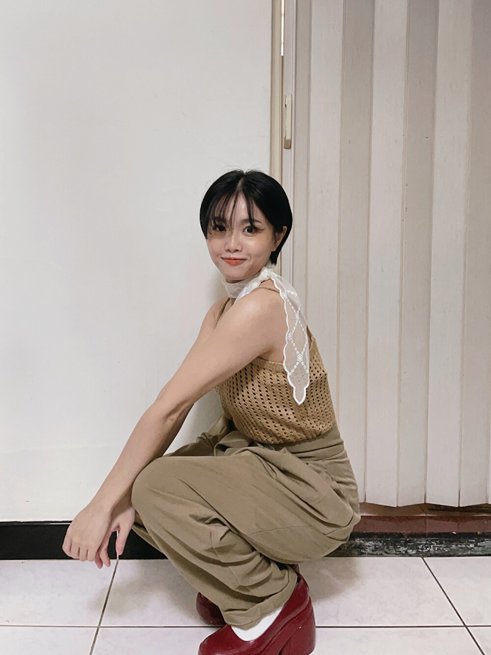 ブラウン系のジャンパースカート、レッド系のパンプスを着用したレディースの夏コーディネートの3枚目の写真
