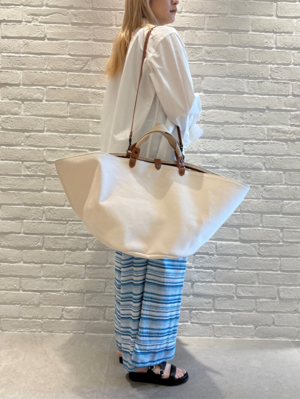 ホワイト系のテーラードジャケット、ブルー系のタンクトップ、ブルー系のその他パンツを着用したレディースの春コーディネートの6枚目の写真