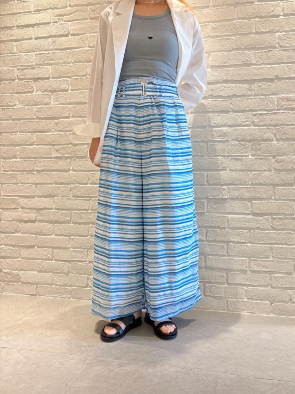 ホワイト系のテーラードジャケット、ブルー系のタンクトップ、ブルー系のその他パンツを着用したレディースの春コーディネートの2枚目の写真