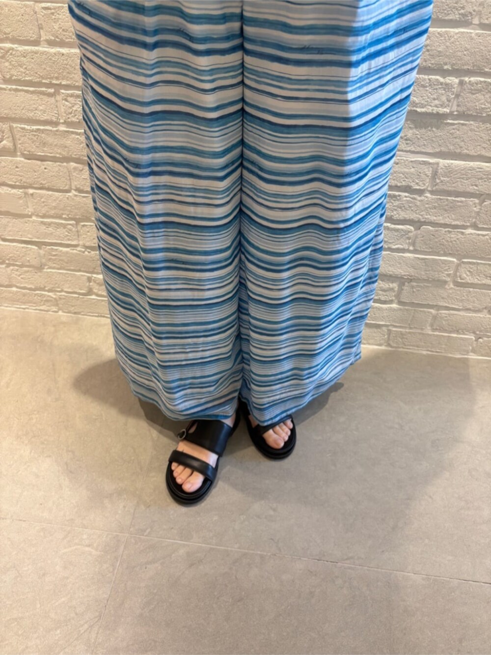 ホワイト系のテーラードジャケット、ブルー系のタンクトップ、ブルー系のその他パンツを着用したレディースの春コーディネートの4枚目の写真