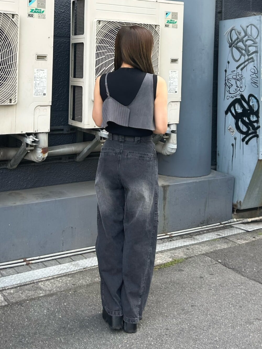 ブラック系のブーツ、ブラック系のタンクトップ、ブラック系のデニムパンツを着用したレディースの夏コーディネートの3枚目の写真