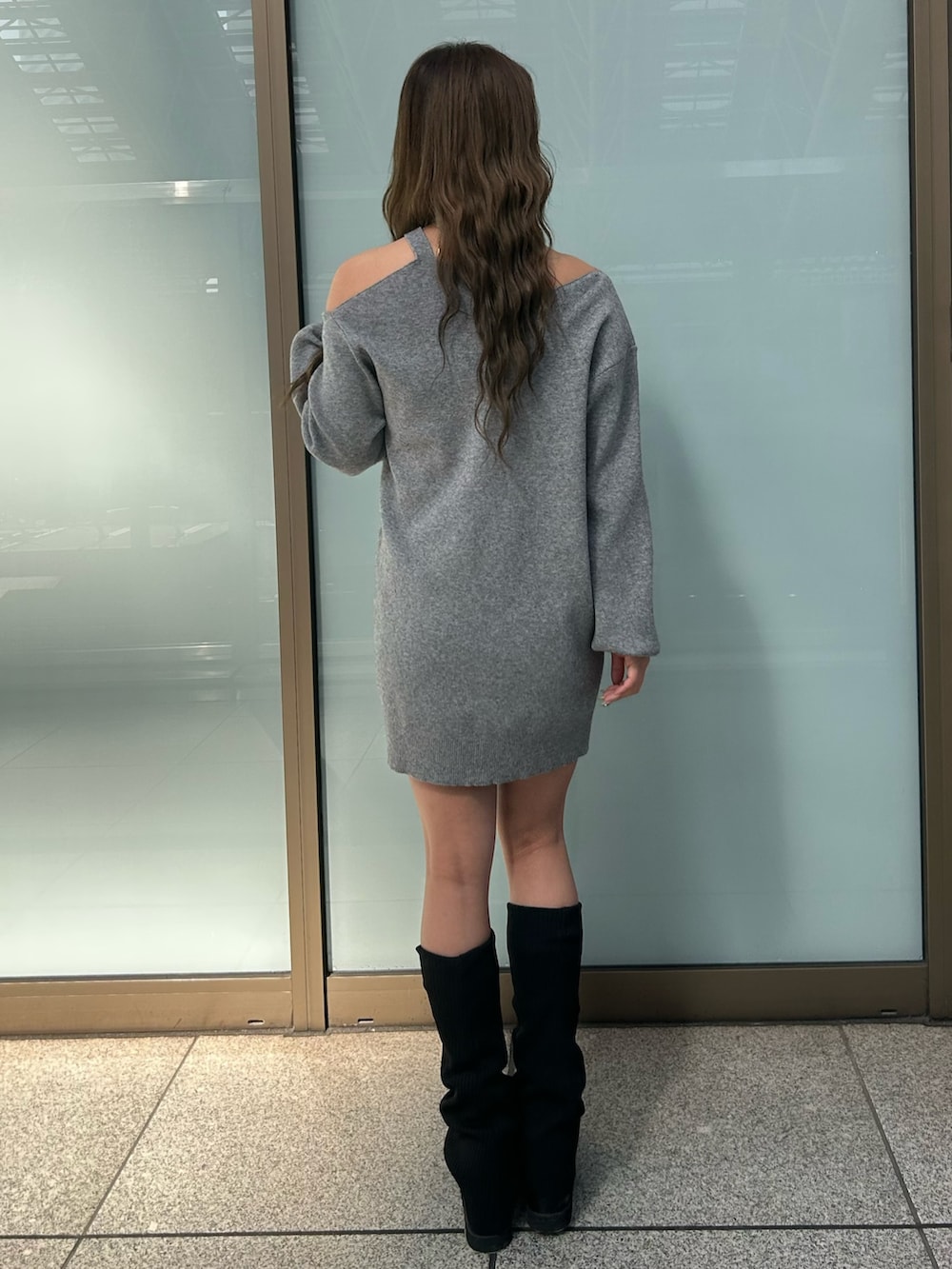 グレー系のワンピース、ブラック系のブーツを着用したレディースの冬コーディネートの3枚目の写真