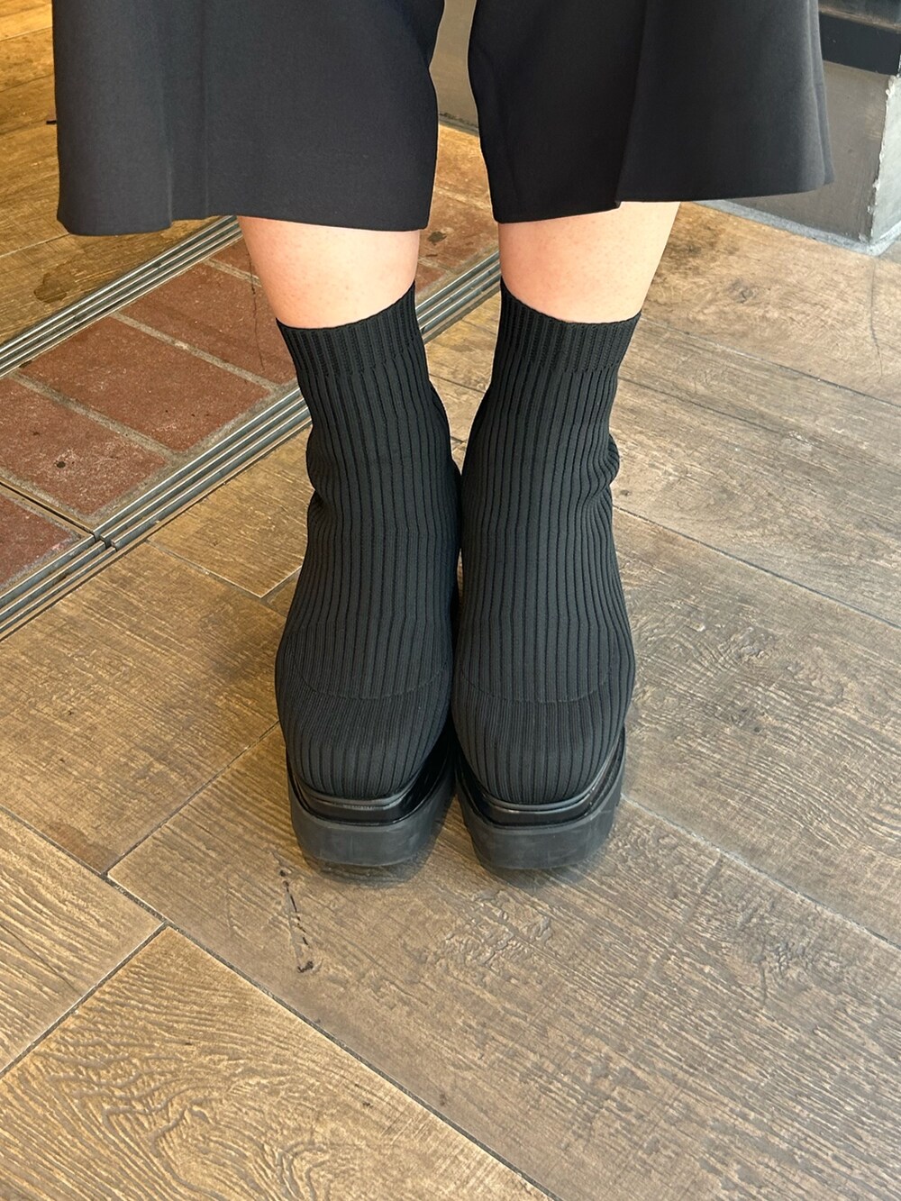 グレー系のニット/セーター、ブラック系のその他パンツ、ブラック系のブーツを着用したレディースの秋コーディネートの5枚目の写真