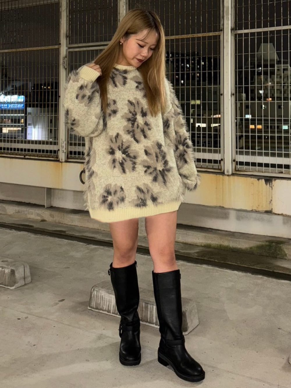 ホワイト系のニット/セーター、ブラック系のブーツを着用したレディースの秋コーディネートの2枚目の写真