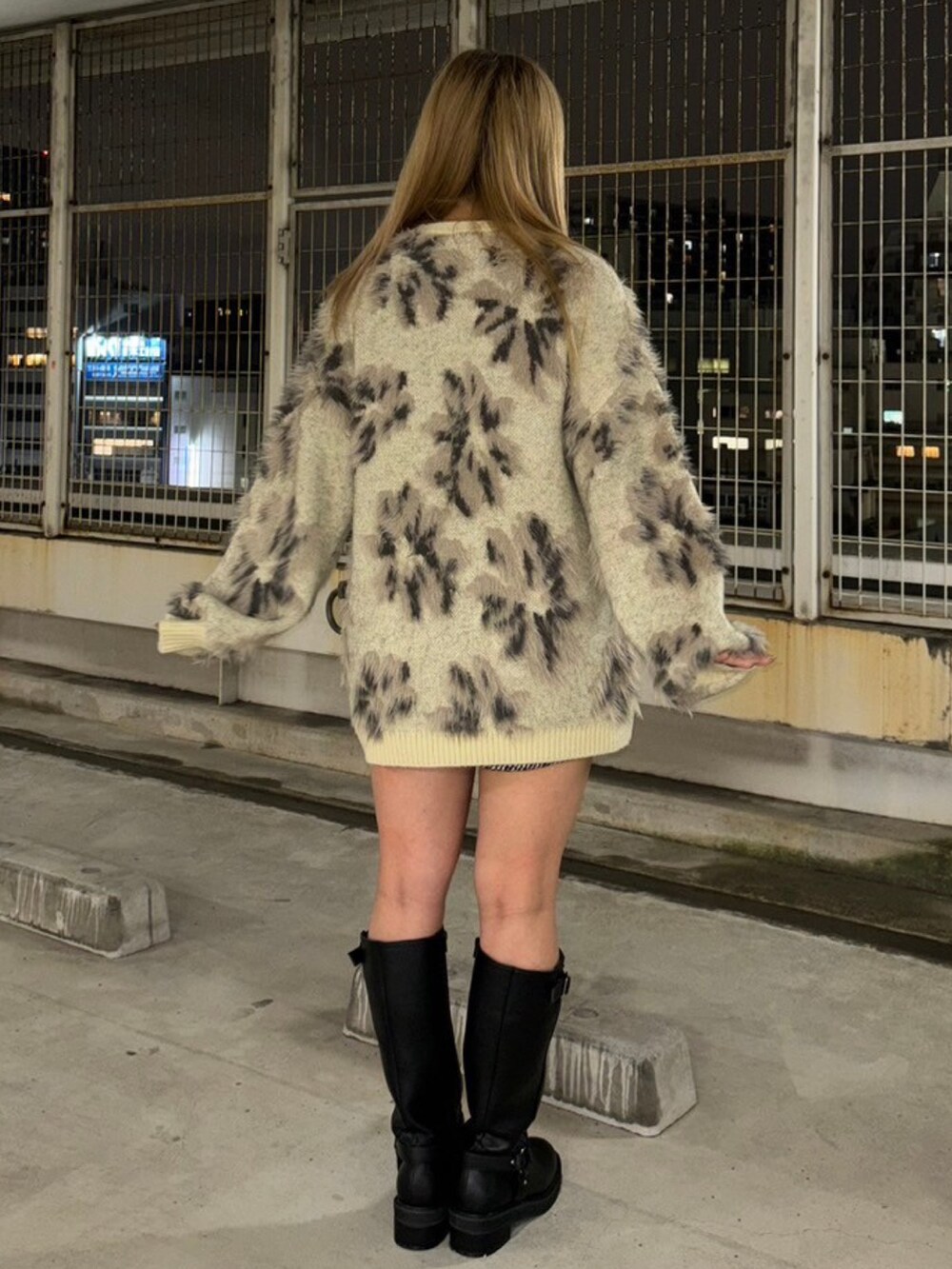 ホワイト系のニット/セーター、ブラック系のブーツを着用したレディースの秋コーディネートの3枚目の写真