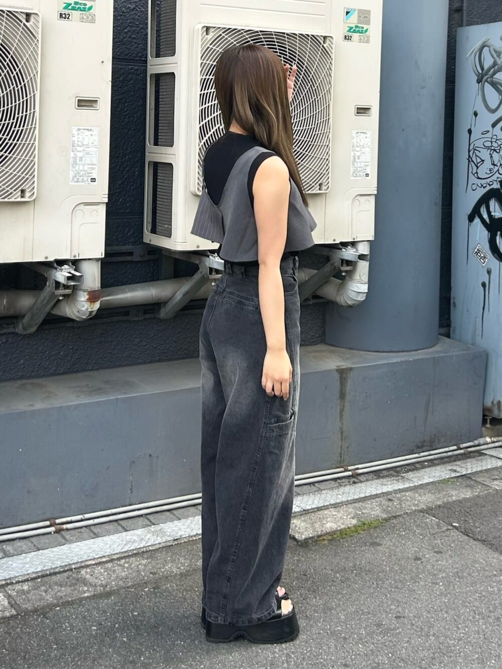 ブラック系のブーツ、ブラック系のタンクトップ、ブラック系のデニムパンツを着用したレディースの夏コーディネートの2枚目の写真