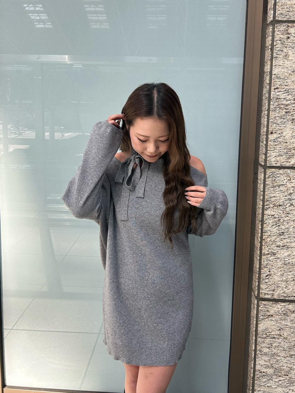 グレー系のワンピース、ブラック系のブーツを着用したレディースの冬コーディネートの4枚目の写真