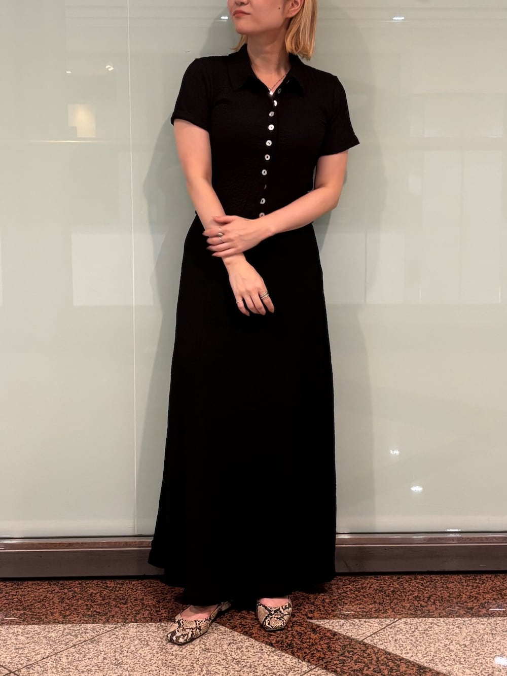 ブラック系のポロシャツ、ブラック系のスカートを着用したレディースの夏コーディネートの2枚目の写真