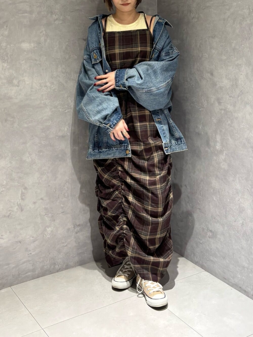 ブルー系のデニムジャケット、レッド系のワンピースを着用したレディースの秋コーディネートの7枚目の写真