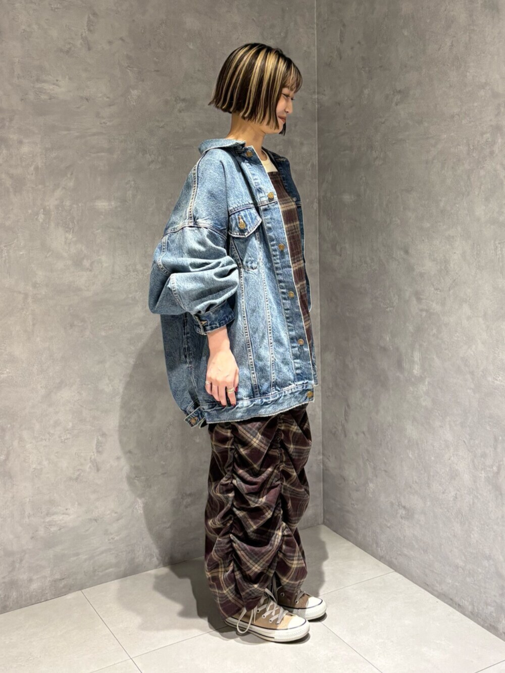 ブルー系のデニムジャケット、レッド系のワンピースを着用したレディースの秋コーディネートの2枚目の写真