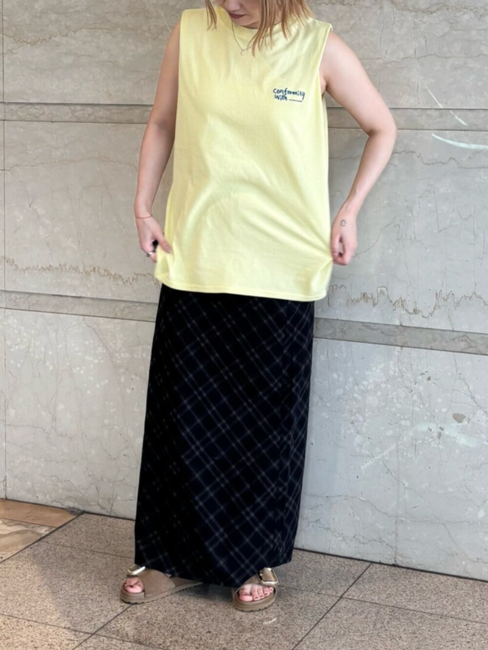 イエロー系のタンクトップ、ブルー系のスカートを着用したレディースの夏コーディネートの4枚目の写真