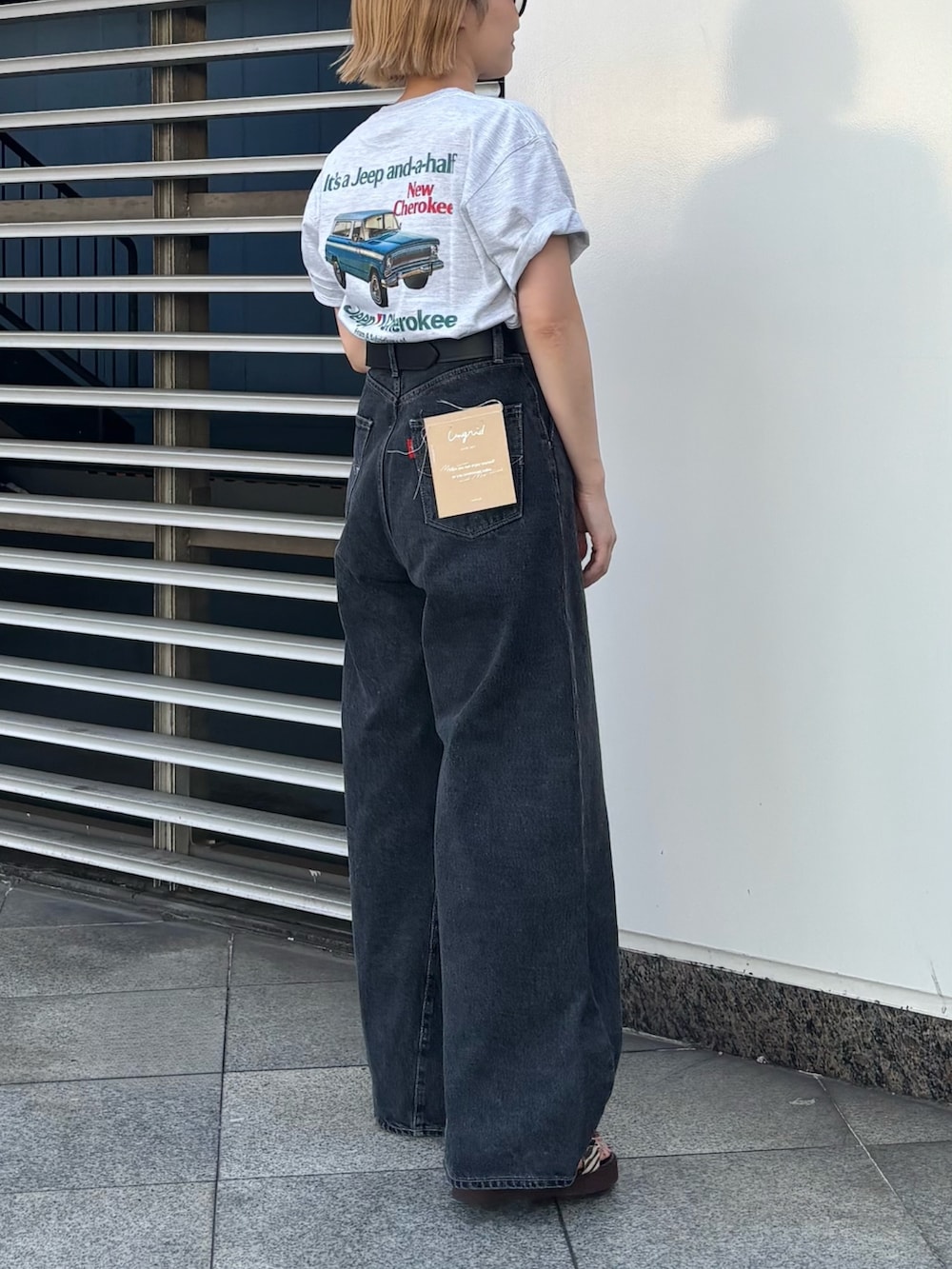 グレー系のTシャツ/カットソー、ブラック系のデニムパンツ、ブラック系のベルトを着用したレディースの夏コーディネートの2枚目の写真