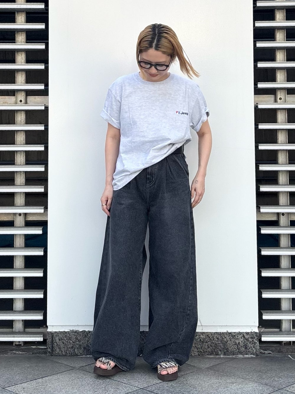 グレー系のTシャツ/カットソー、ブラック系のデニムパンツ、ブラック系のベルトを着用したレディースの夏コーディネートの6枚目の写真