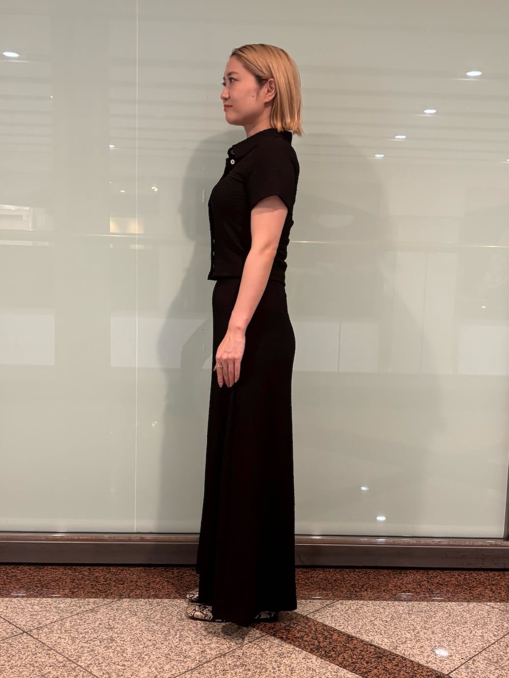 ブラック系のポロシャツ、ブラック系のスカートを着用したレディースの夏コーディネートの3枚目の写真