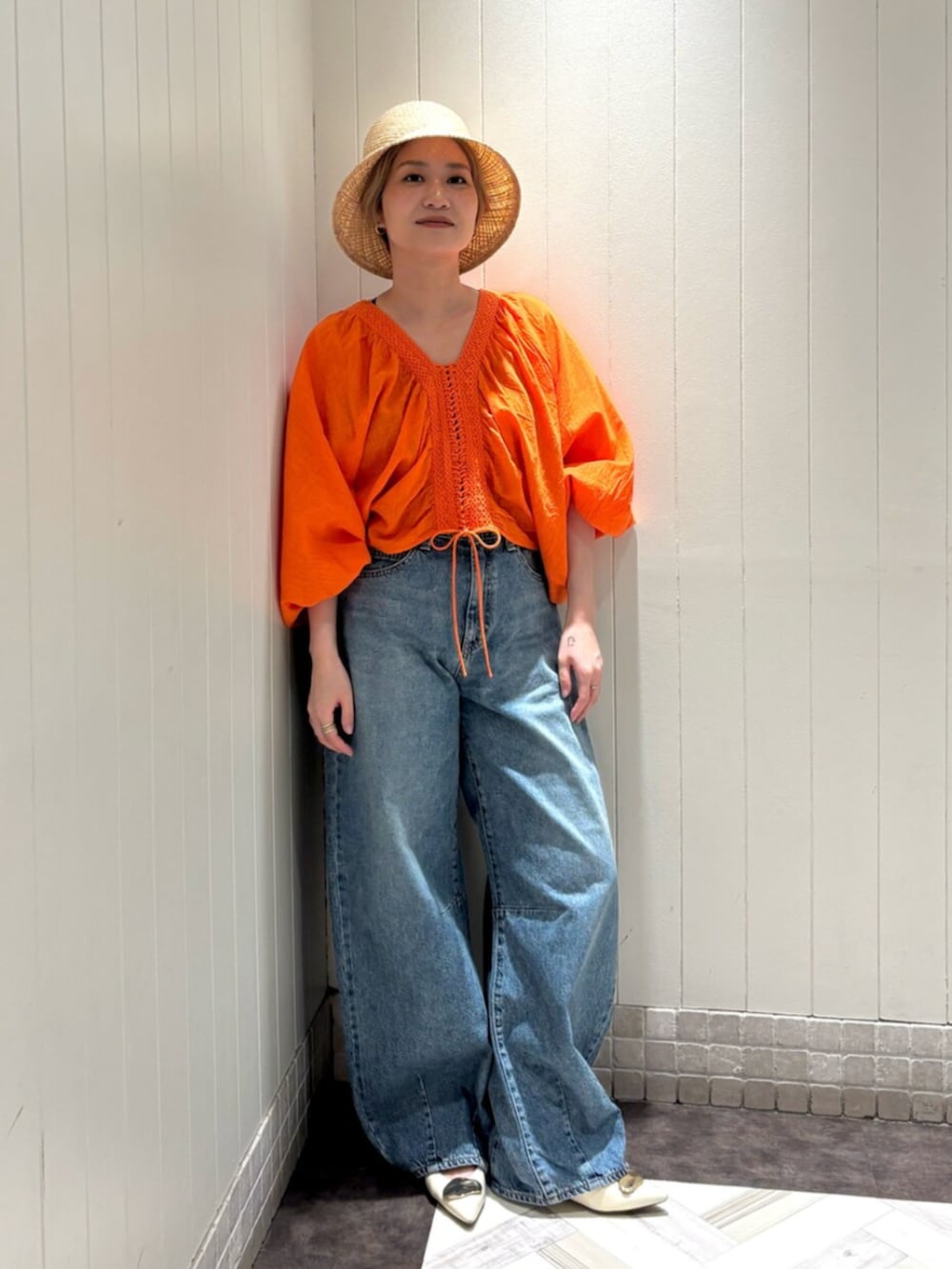 オレンジ系のシャツ/ブラウス、ブルー系のデニムパンツ、ベージュ系のハットを着用したレディースの夏コーディネートの5枚目の写真