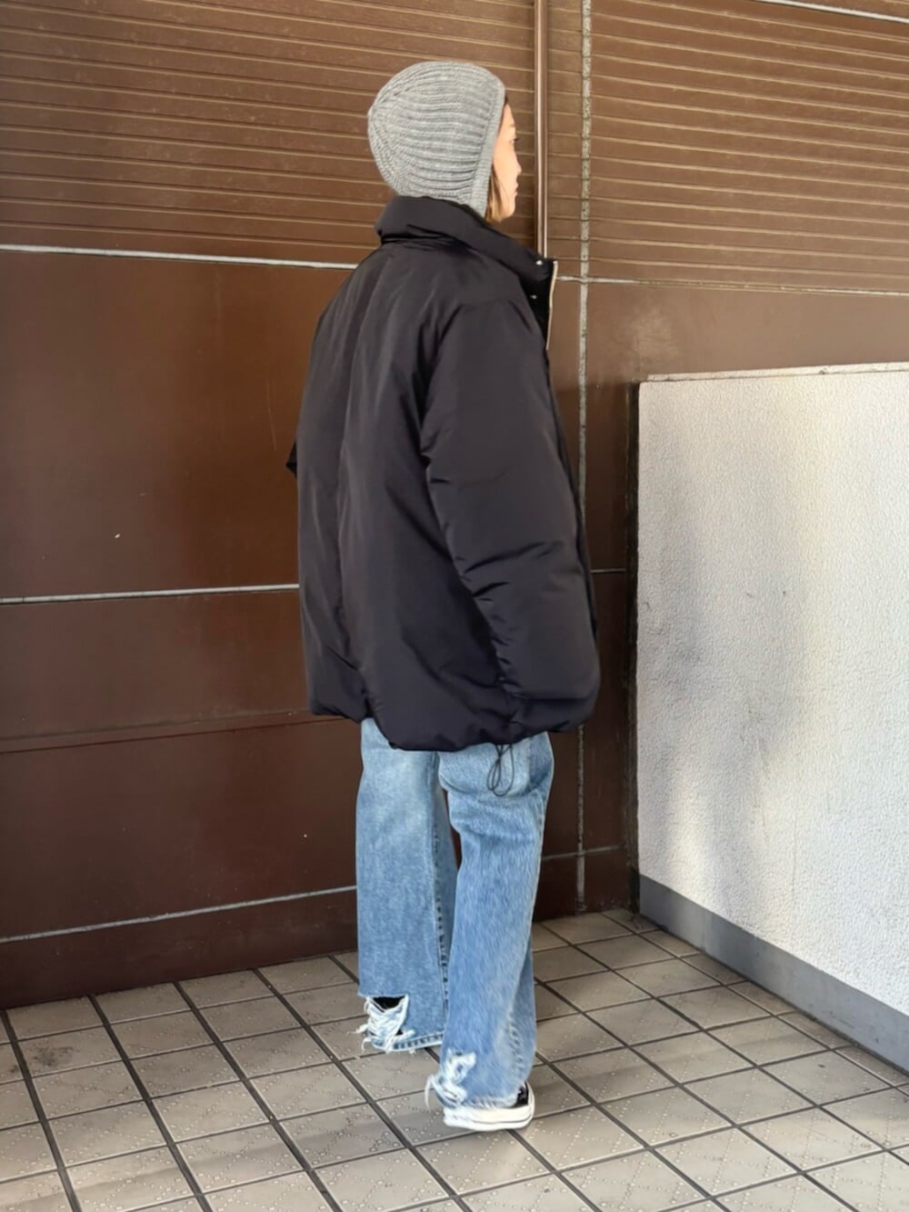 ブラック系のダウンジャケット/コート、レッド系のニット/セーター、ブルー系のデニムパンツを着用したレディースの冬コーディネートの5枚目の写真