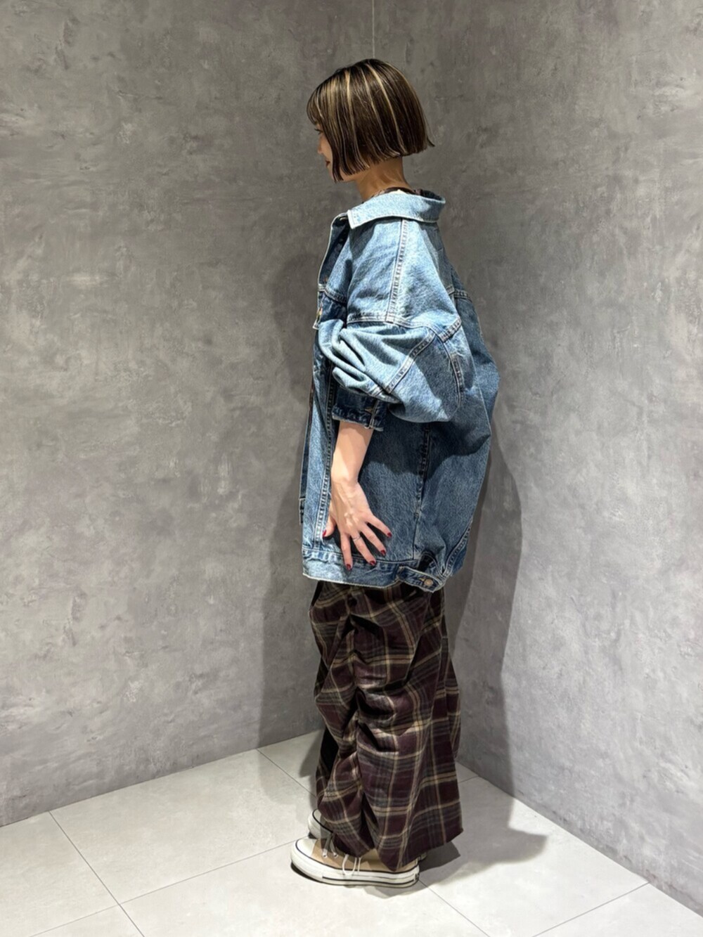 ブルー系のデニムジャケット、レッド系のワンピースを着用したレディースの秋コーディネートの5枚目の写真