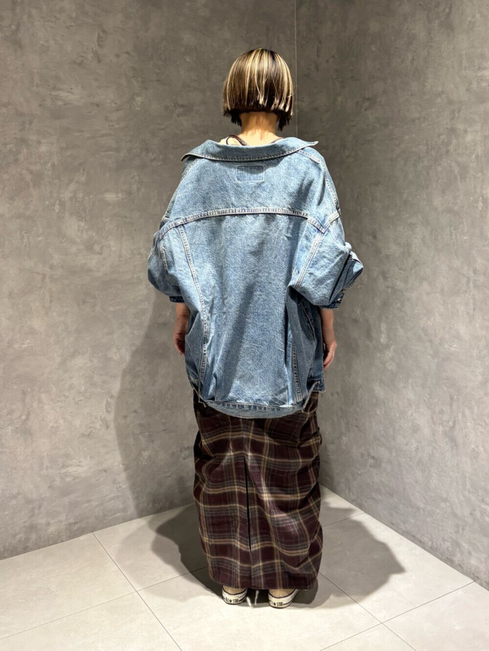 ブルー系のデニムジャケット、レッド系のワンピースを着用したレディースの秋コーディネートの3枚目の写真