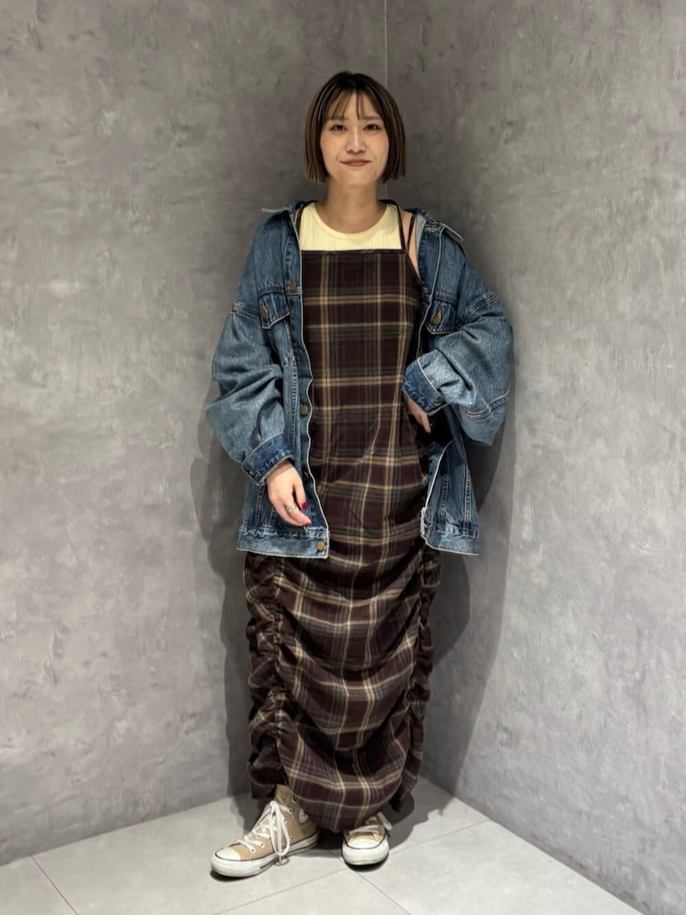 ブルー系のデニムジャケット、レッド系のワンピースを着用したレディースの秋コーディネートの6枚目の写真