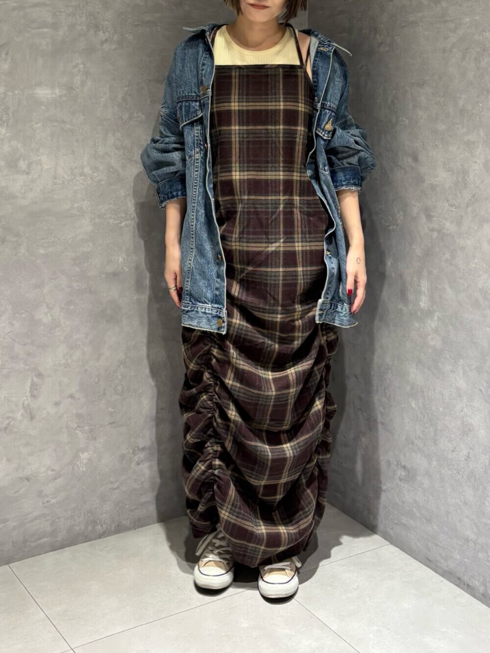 ブルー系のデニムジャケット、レッド系のワンピースを着用したレディースの秋コーディネートの4枚目の写真