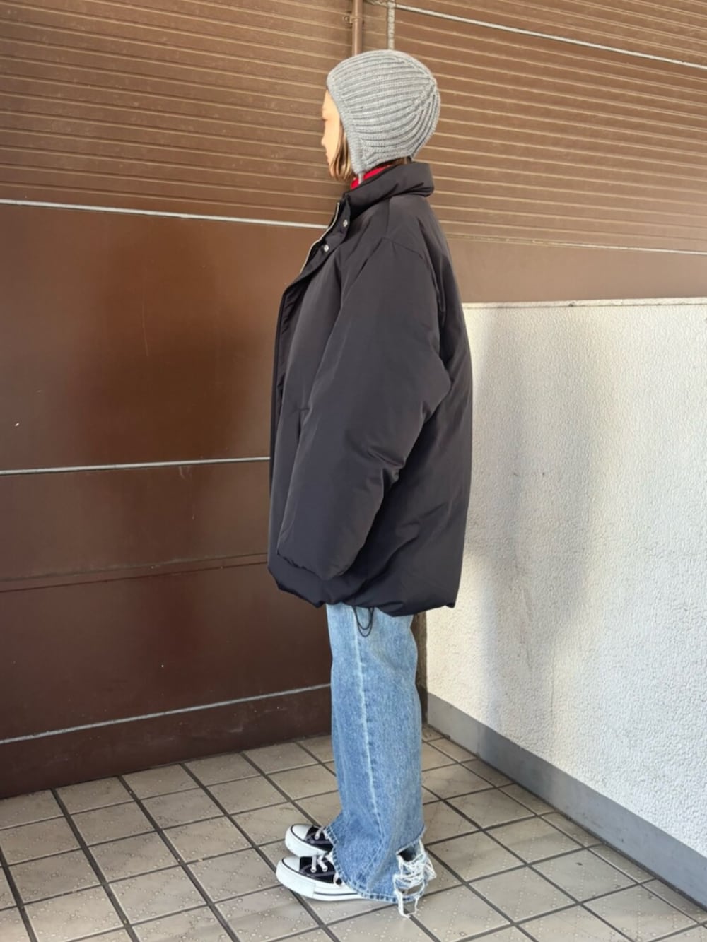 ブラック系のダウンジャケット/コート、レッド系のニット/セーター、ブルー系のデニムパンツを着用したレディースの冬コーディネートの3枚目の写真