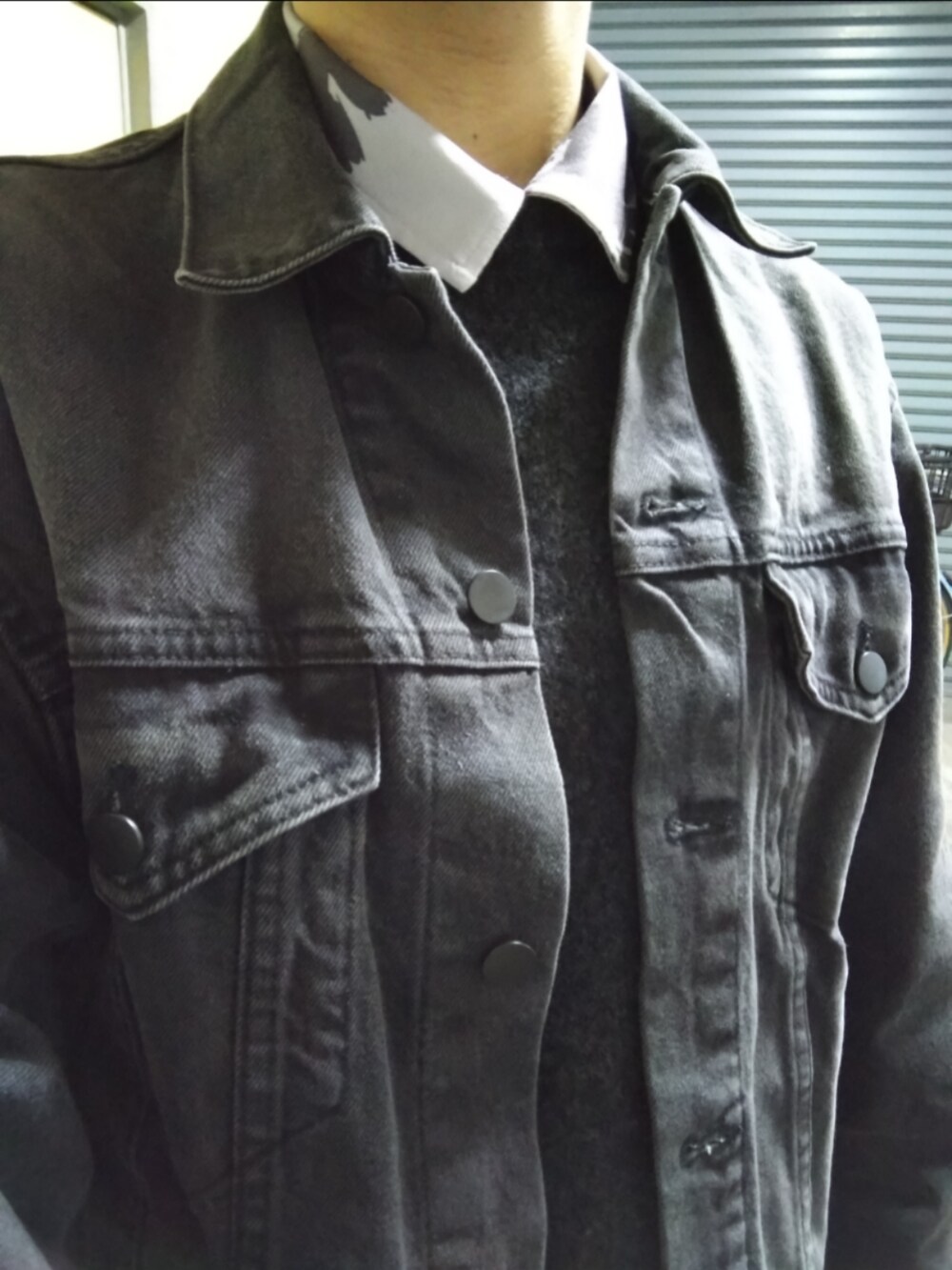 ブラック系のニット/セーター、ブラック系のデニムジャケット、グレー系のシャツ/ブラウスを着用したメンズの秋コーディネートの2枚目の写真