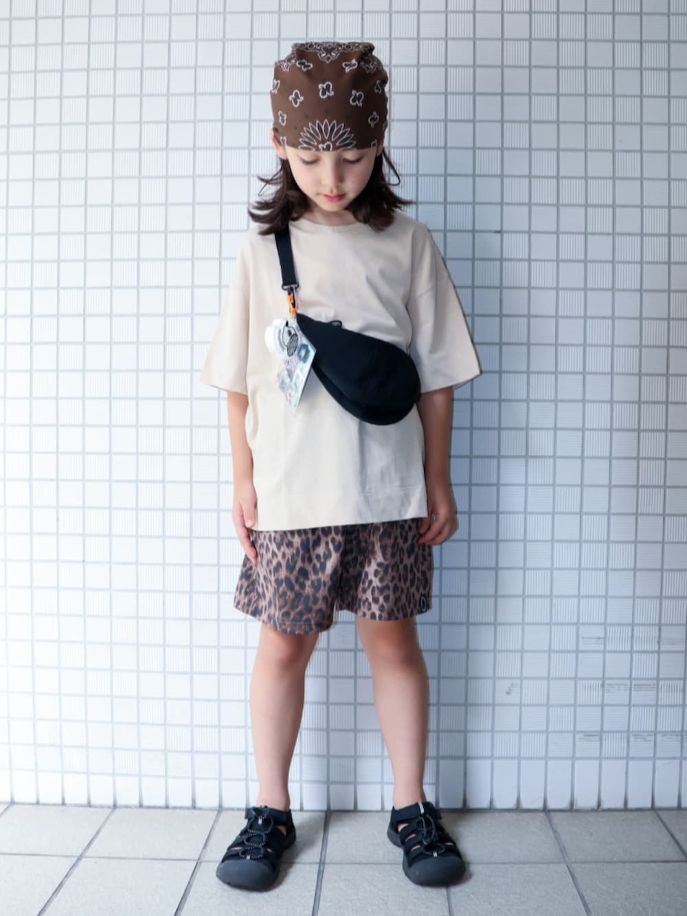 ブラック系のサンダル、ベージュ系のその他パンツ、ベージュ系のカーディガン/ボレロを着用したキッズの夏コーディネートの2枚目の写真
