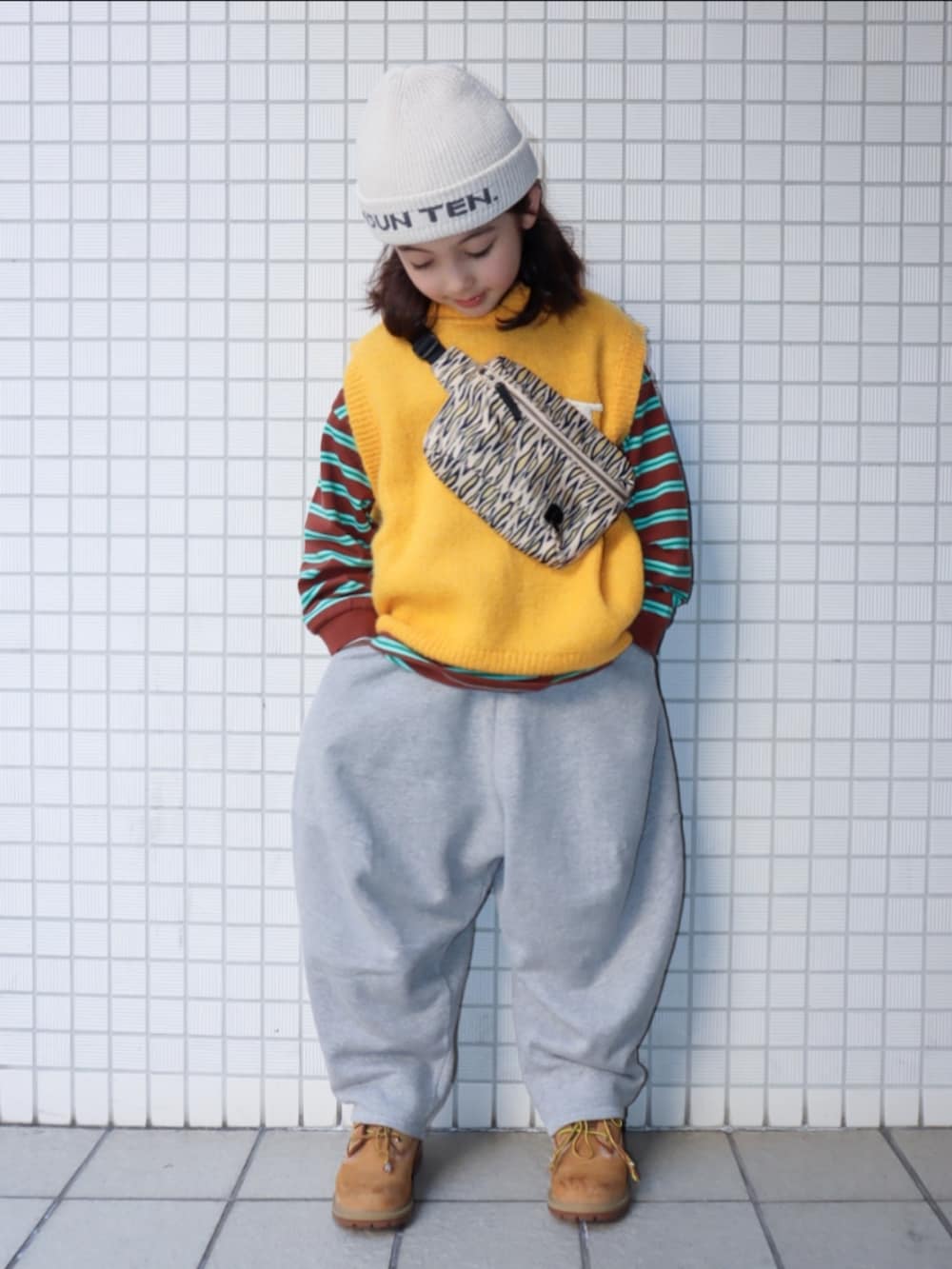 ベージュ系のブーツ、グレー系のスウェットパンツ、その他のショルダーバッグを着用したキッズの春コーディネートの2枚目の写真