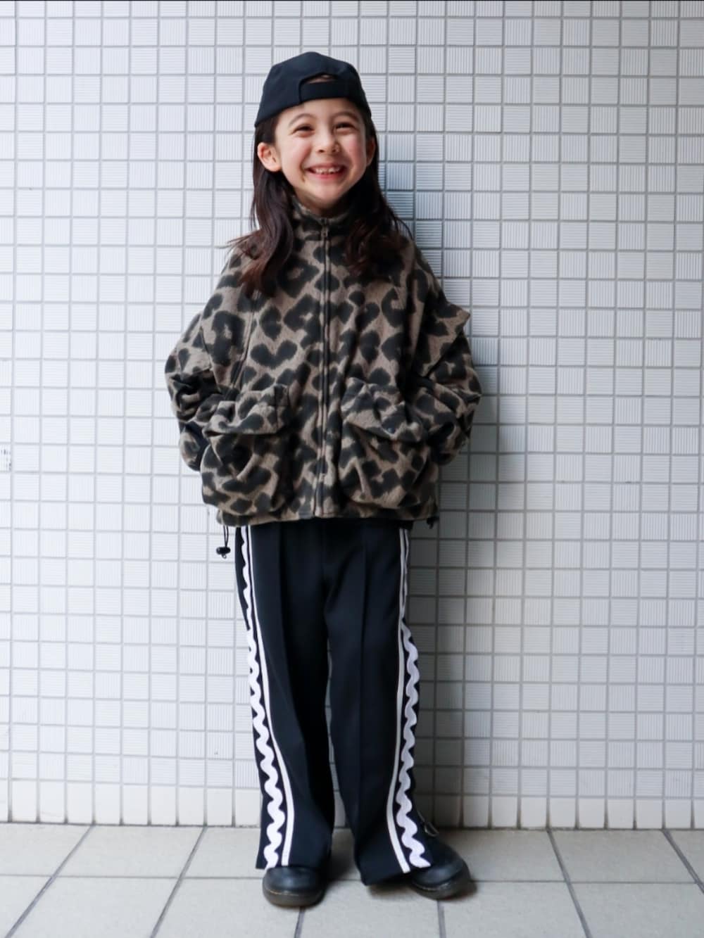 ベージュ系のジャケット/アウター、ブラック系のパンツ、ブラック系のキャップを着用したキッズの冬コーディネートの2枚目の写真